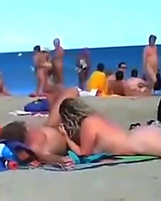 A bunch of nudists have sex on the beach